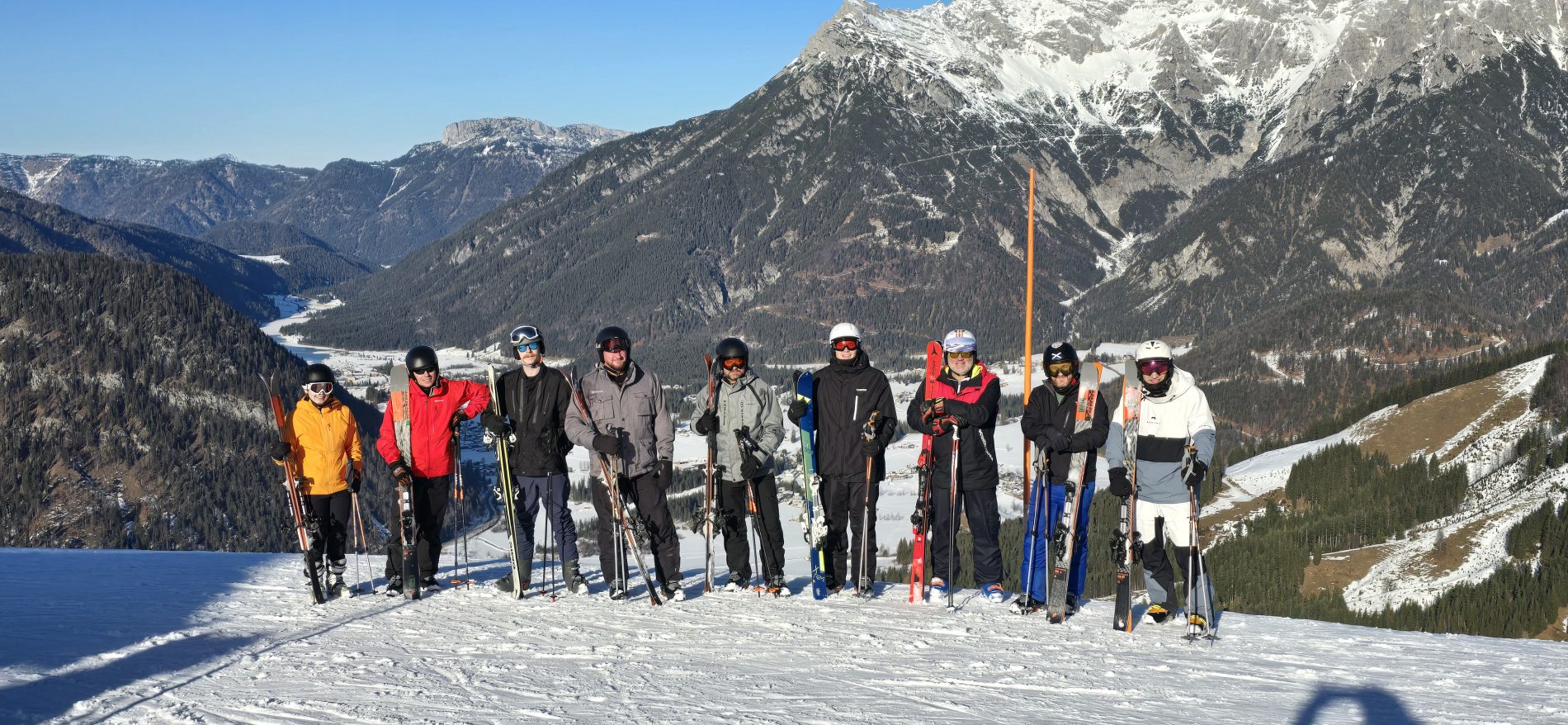 Ski Foundation 2 group at the top of a blue 1 run, with mountains in the background.