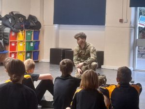 A cadet speaking to a classroom of students.